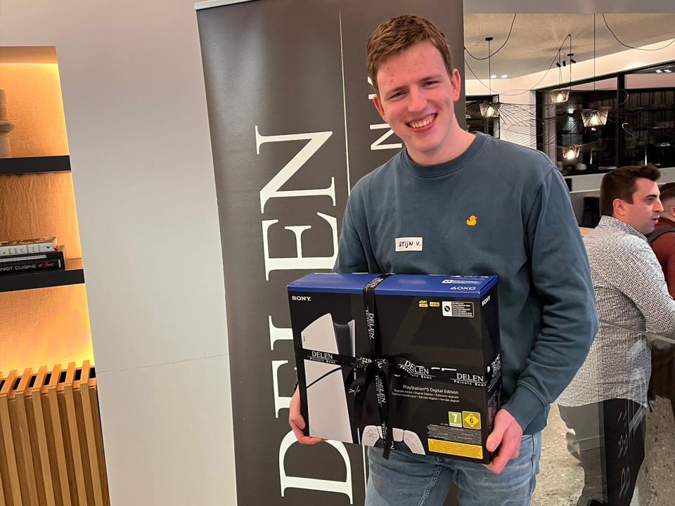 Een trotse Stijn poseert samen met zijn prijs, een Playstation 5